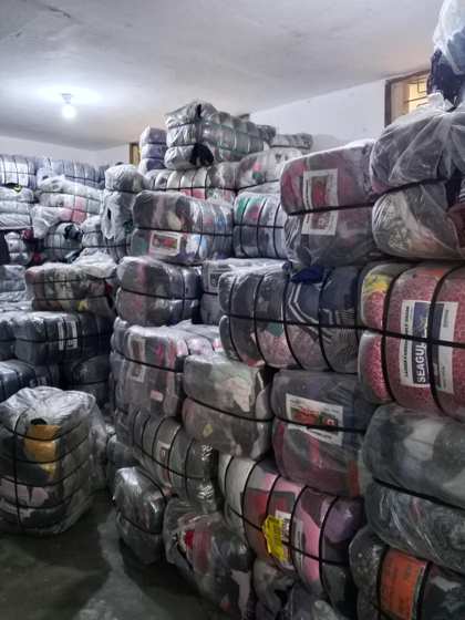 Warehouse stacked with women, men and children okrika bales